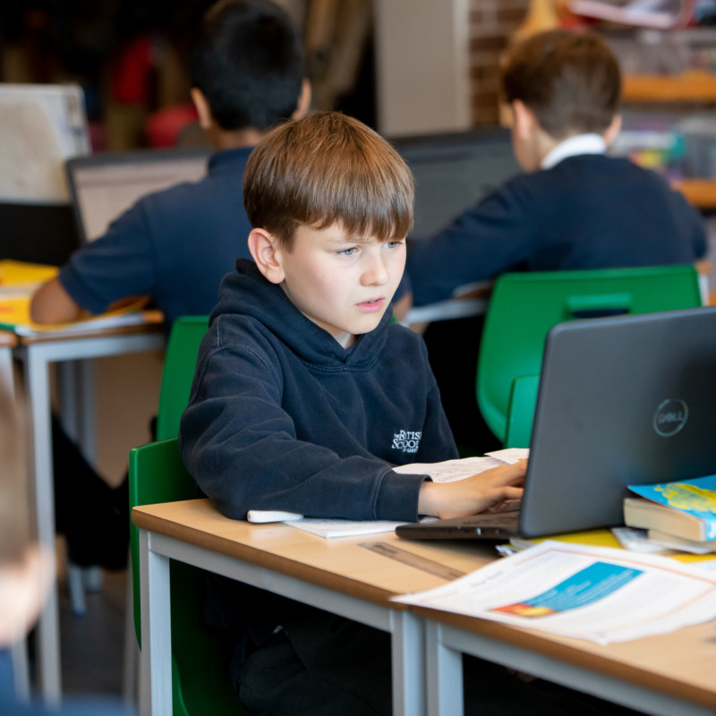 Junior student working on a laptop during class